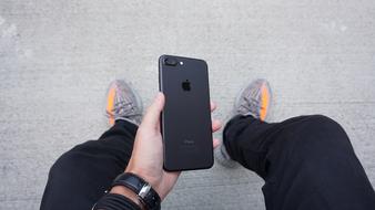 Man, holding beautiful, black Iphone in the hand, with wrist watch