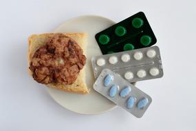 meatballs and medicines on plate, unhealthy food