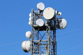 telecommunications with antennas on blue sky background