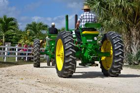 farmers on green tractors on a sunny day