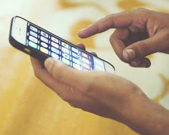 Person, using white Iphone with colorful icons of apps