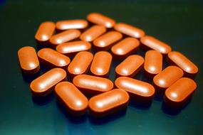 brown pills on a dark table