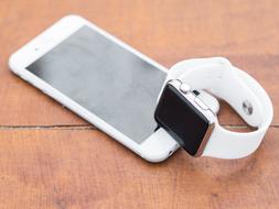 Iphone Iwatch on a wooden surface close up