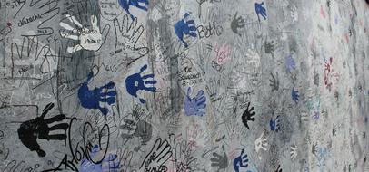 image of handprints on the Berlin wall