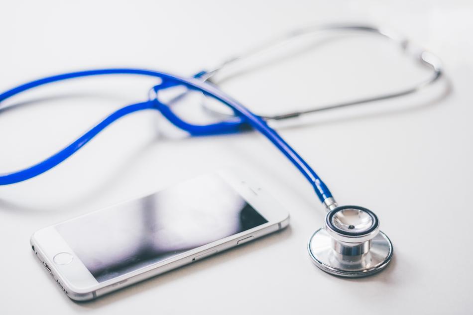 smartphone and stethoscope on white