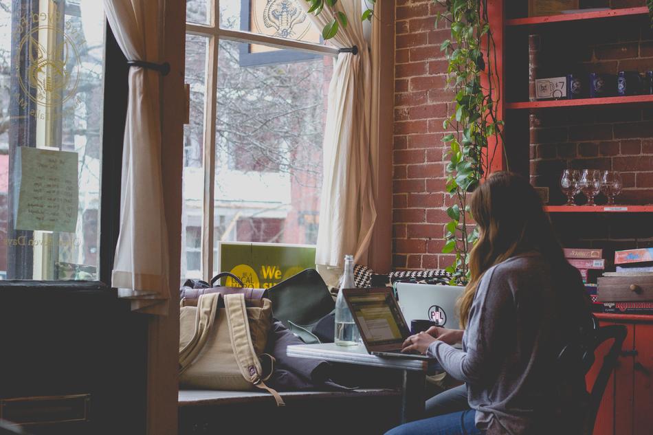 young woman with laptop in cafe