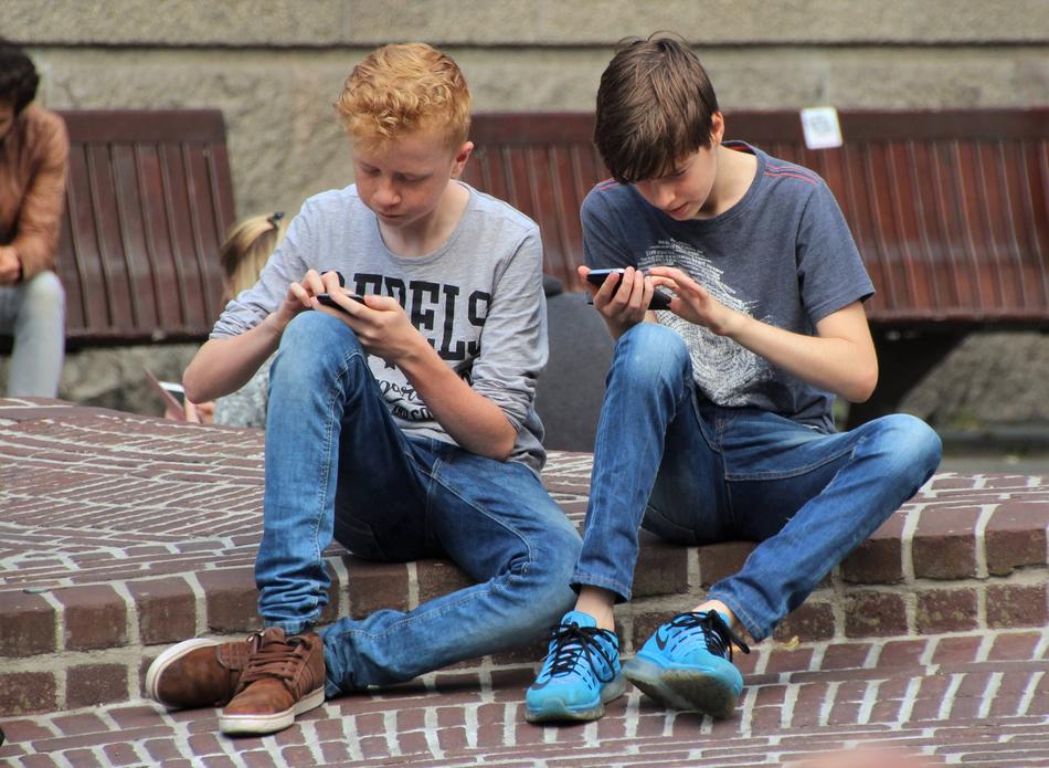teens play on the phone and look for Pokemon in the street