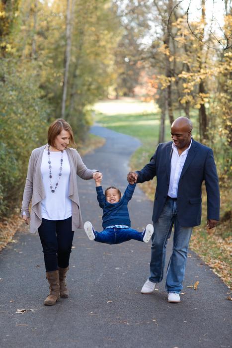 Couple with the child on the beautiful road, among the colorful trees