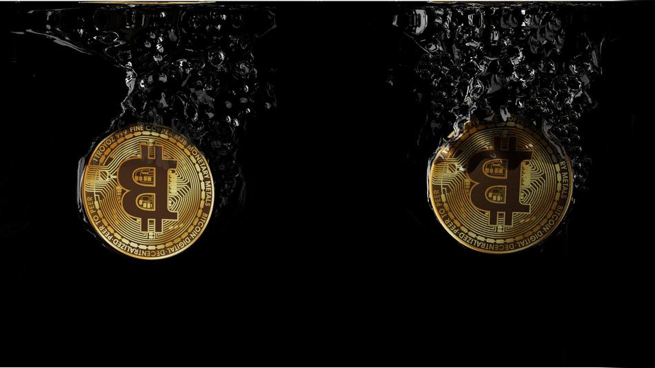 bitcoins in splashes of water at darkness