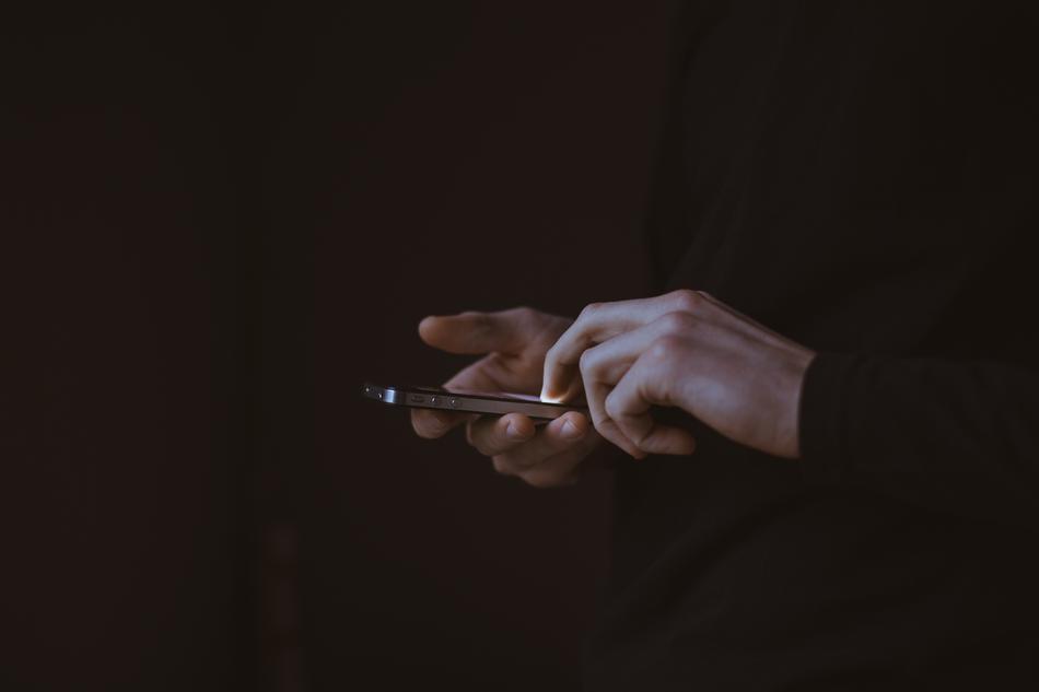 man hands with smartphone in the dark