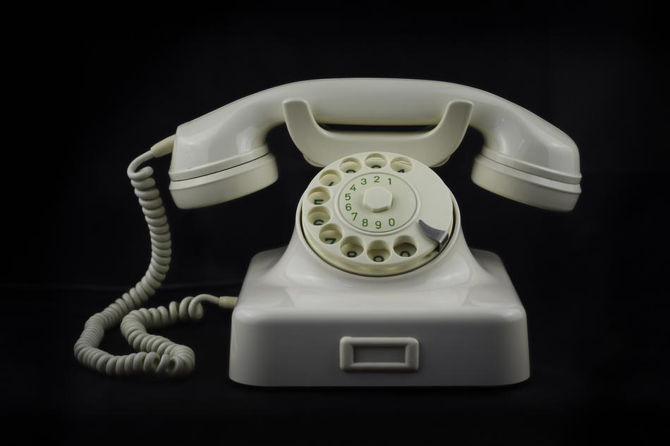 white retro phone on a black background