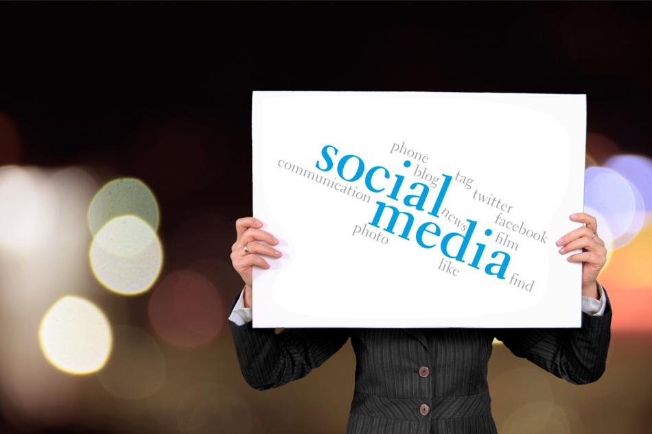 banner with the inscription social media in the hands of a businesswoman