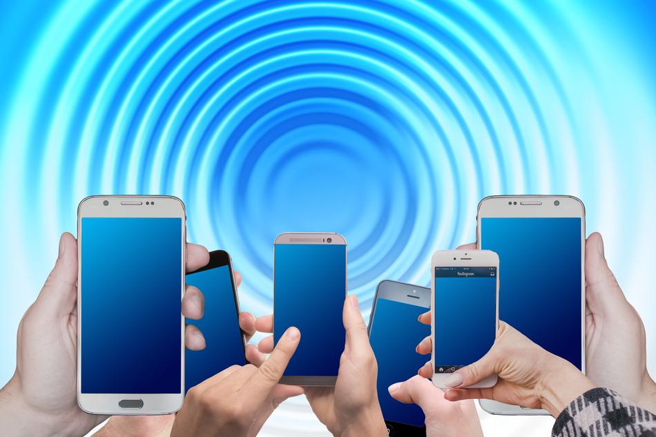 Smartphones in the hands, at blue and white background with the swirl, on clipart