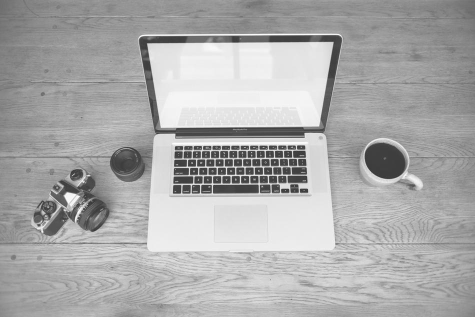 camera and cup near laptop