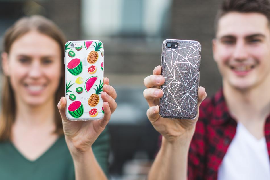Woman and man, holding smartphones in colorful, patterned cases