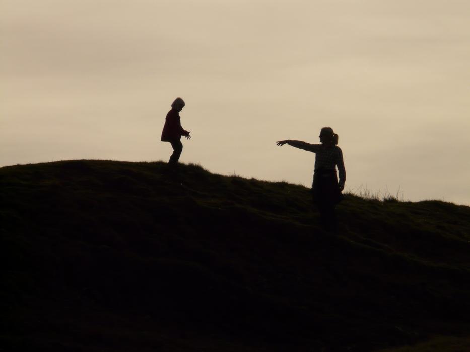 silhouette of mom and baby on the top of the hill