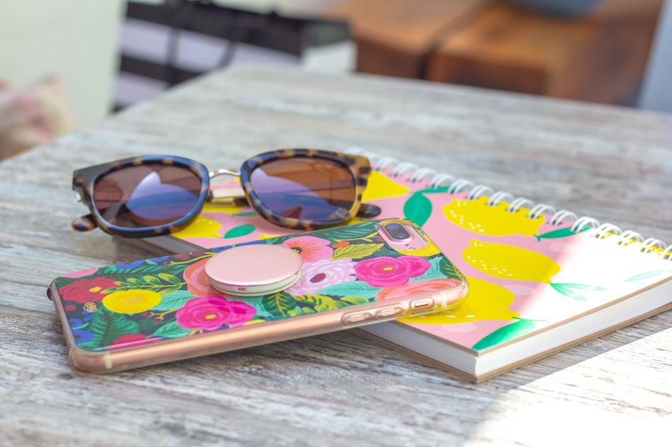 Beautiful and colorful notebook, Iphone and sunglasses, on the wooden table in light