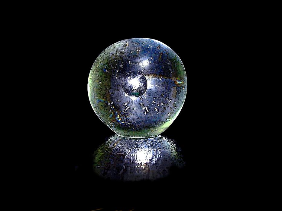 glass ball is reflected on a black surface