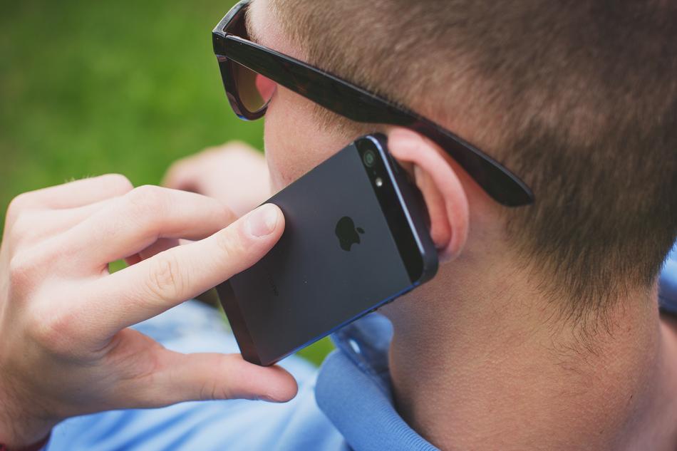 Man in glasses, talking on the black Iphone