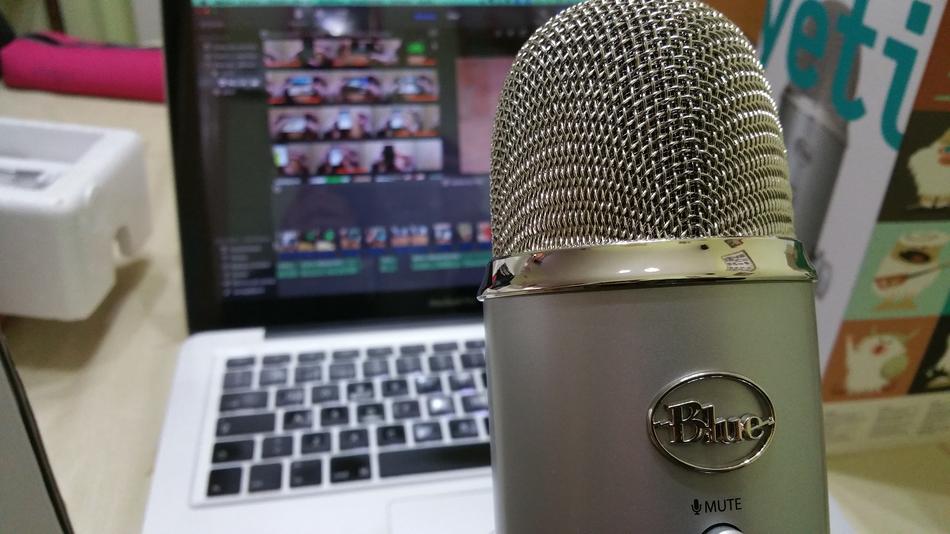 Close-up of the beautiful, gray microphone near the white and black laptop