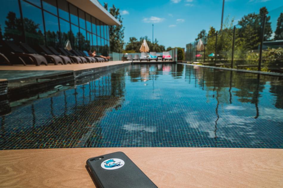Smartphone, laying near the beautiful swimming pool with reflections