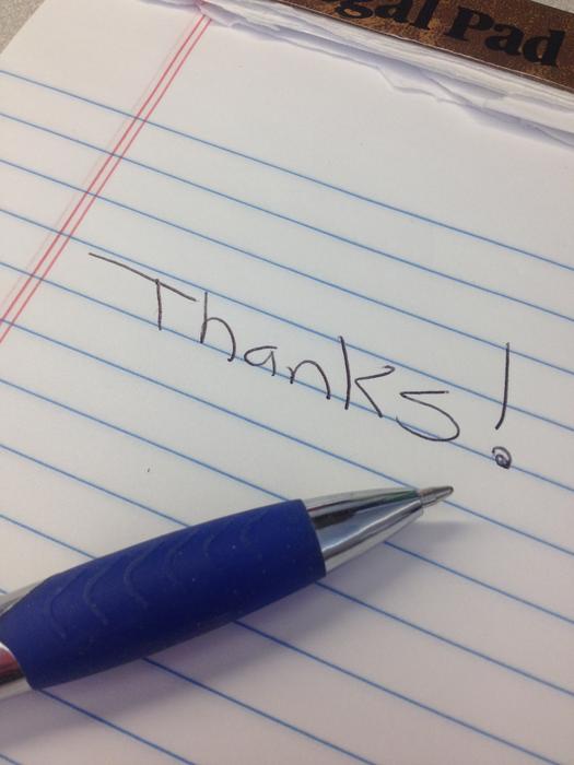 Shiny, blue pen on the notebook, with the 'Thanks!' sign