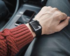 man with a black wristwatch in a car salon