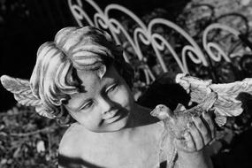 sculpture of an angel in the garden in monochrome blurred background