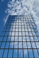 Close-up of the window building with reflections, under the blue sky with white clouds