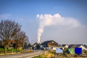 white smoke from a nuclear power plant over the village