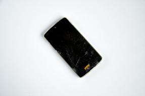 Black, broken smartphone, on the white surface