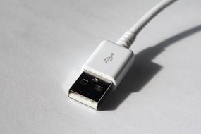 Close-up of the white USB cable, with the wire, with shadow, in light