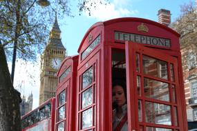 woman in red telephone booth on the streets of london