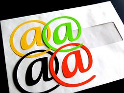 Colorful "@" signs on the white letter, at black background, clipart