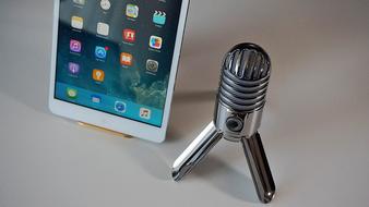 Shiny microphone near the white tablet on the stand