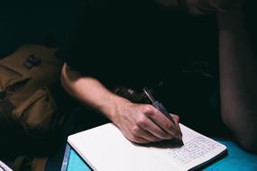 Man Writing on notebook at sunlight