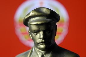 Shiny statue of Lenin, at background with the sign of USSR