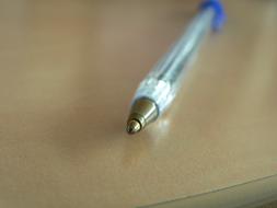 Close-up of the shiny pen, on the table with reflections