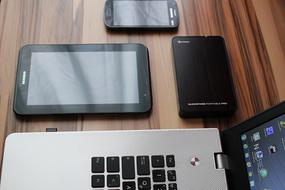 Shiny devices on the brown, wooden table