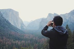man photographs mountains