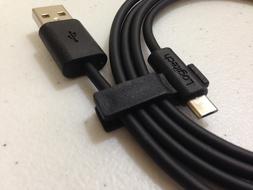 Close-up of the black "Logitech" USB cable with signs, in light, with the shadow