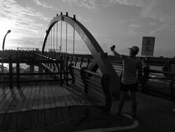 Black and white photo with the person, near the bridge in the Hualien Port, Taiwan, at sunrise