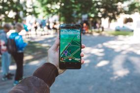 modern gadget in hand in the park on a blurred background