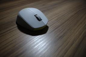 wireless computer mouse on wooden table