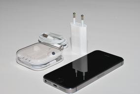 Iphone with accessories and devices, on the white table