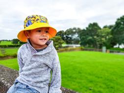 portrait of a little boy against the background of a green field