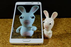 a figurine of a hare next to a mobile phone