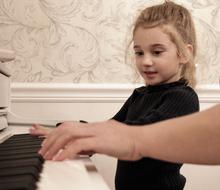 girl learns to play the piano