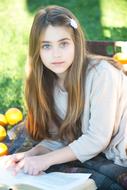 photo of a girl with long hair reading a book