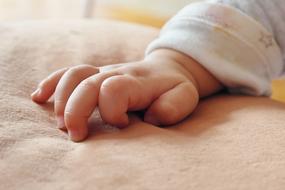 photo of baby's hand on a blanket